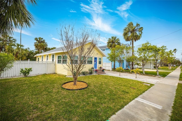 view of front of home with fence, concrete driveway, and a front yard