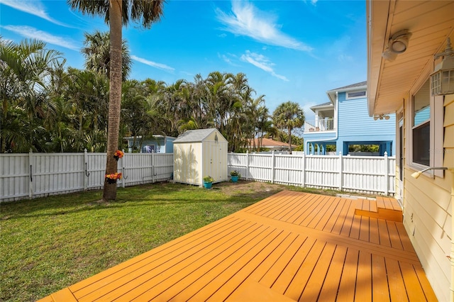 wooden deck with an outdoor structure, a yard, a shed, and a fenced backyard