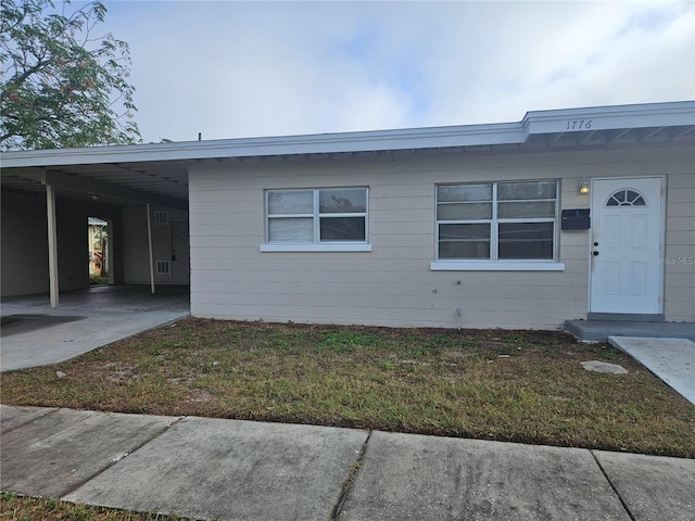 view of front facade featuring a carport and a front yard