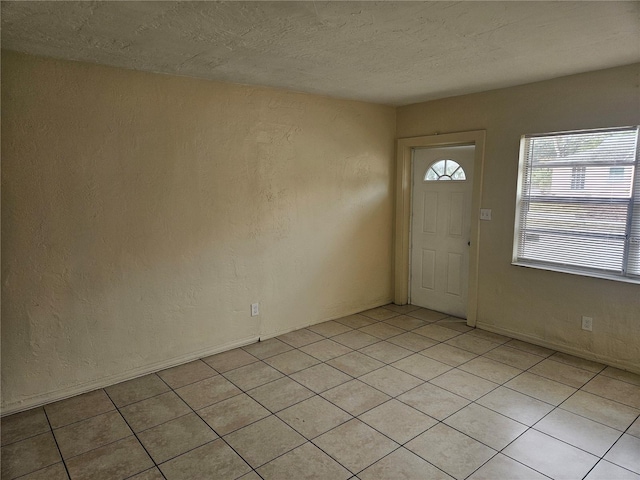 foyer featuring a textured wall and a textured ceiling