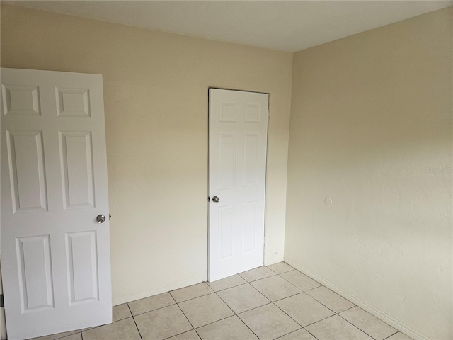 unfurnished bedroom with baseboards and light tile patterned floors