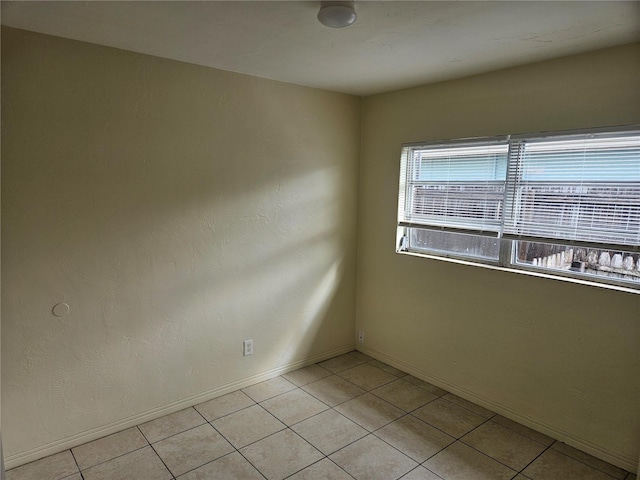 unfurnished room featuring light tile patterned floors and baseboards