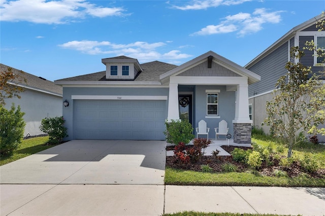 craftsman-style home featuring driveway, roof with shingles, a garage, and stucco siding