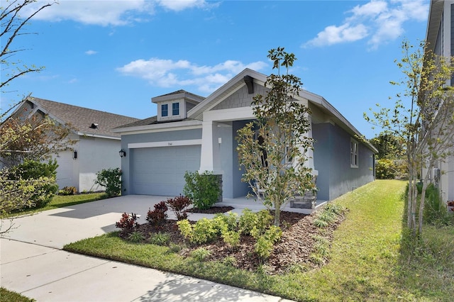 view of front of home featuring a garage, a front yard, concrete driveway, and stucco siding