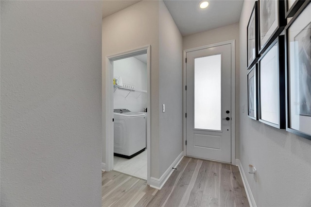 entryway featuring light wood-style floors, washer / clothes dryer, and baseboards