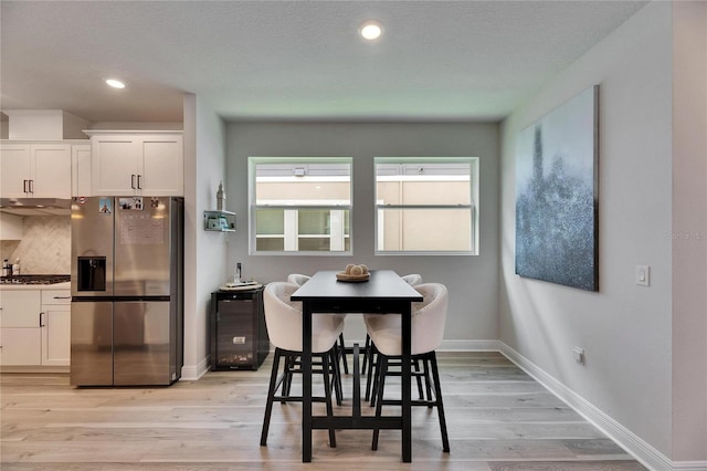 dining room featuring recessed lighting, baseboards, and light wood finished floors