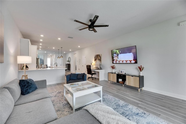 living room with recessed lighting, visible vents, light wood-style floors, a ceiling fan, and baseboards