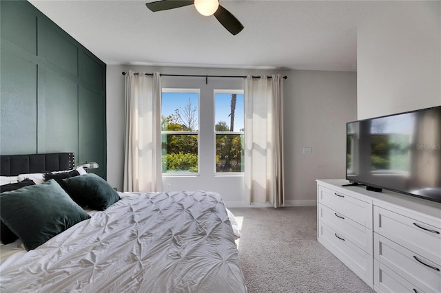 bedroom with light carpet, a ceiling fan, and baseboards