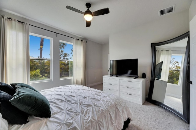 bedroom featuring visible vents, light carpet, baseboards, and multiple windows