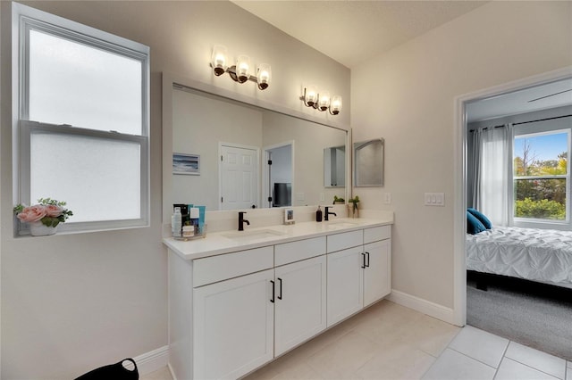 full bath featuring double vanity, ensuite bath, baseboards, and a sink