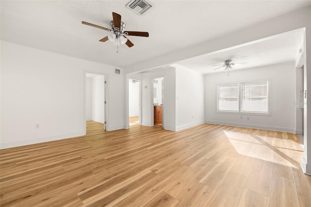 spare room featuring light wood-style flooring, visible vents, ceiling fan, and baseboards