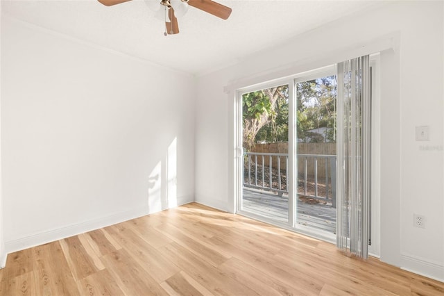 empty room featuring a ceiling fan, ornamental molding, baseboards, and wood finished floors