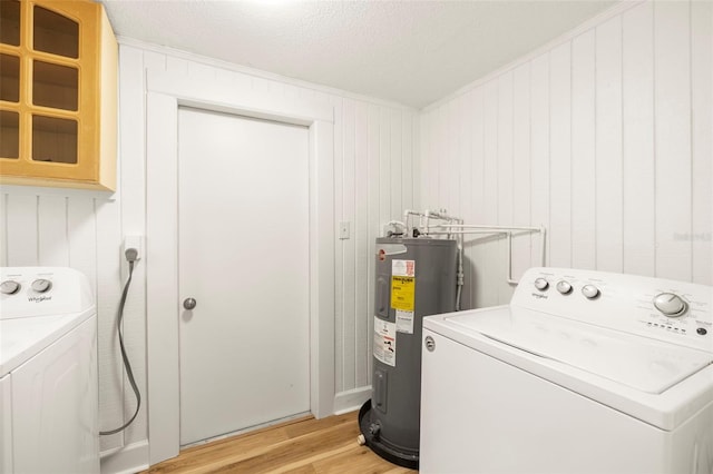 laundry room with a textured ceiling, washing machine and dryer, light wood-style flooring, laundry area, and water heater