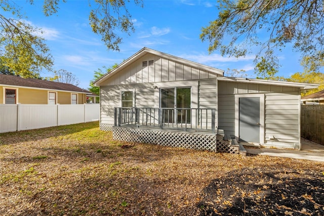 back of house with a fenced backyard, a deck, and board and batten siding