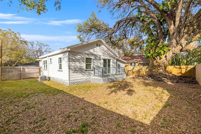 rear view of property with cooling unit, a fenced backyard, a lawn, and a deck