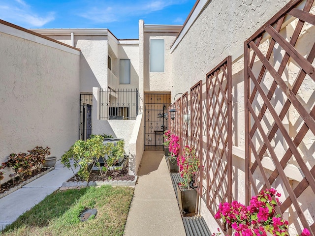 exterior space with fence, a gate, and stucco siding