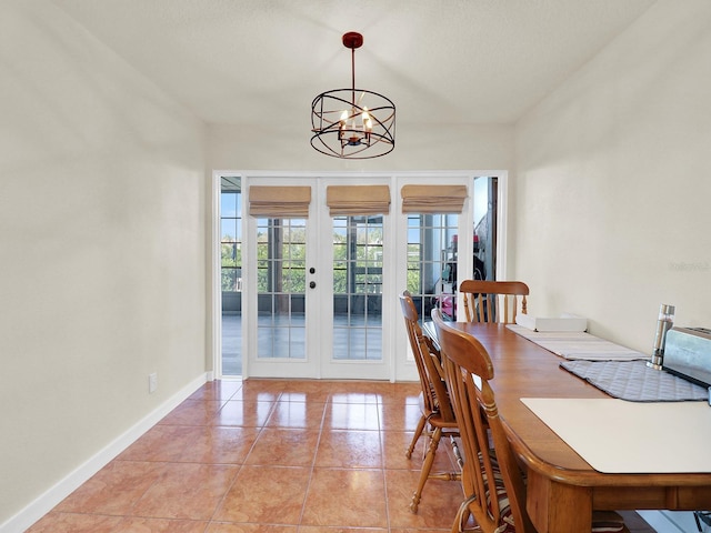 dining space featuring baseboards, french doors, light tile patterned flooring, and a notable chandelier