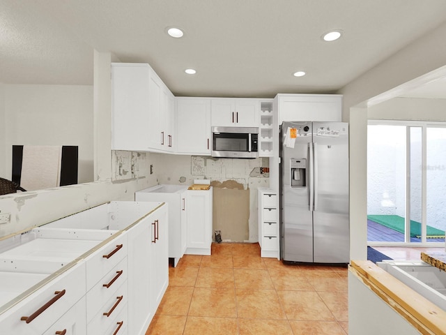 kitchen with white cabinets, light tile patterned floors, appliances with stainless steel finishes, and open shelves