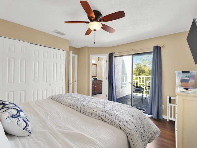 bedroom with visible vents, dark wood finished floors, access to exterior, a textured ceiling, and a closet