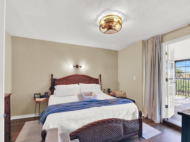 bedroom with a textured ceiling, access to outside, wood finished floors, and baseboards