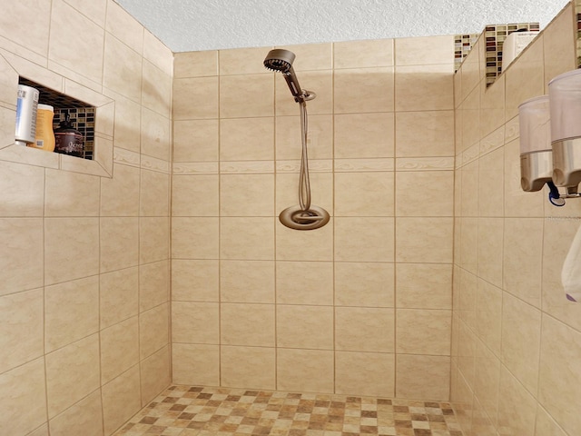 full bath featuring a tile shower and a textured ceiling