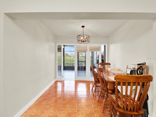 dining area featuring a notable chandelier, french doors, light tile patterned flooring, and baseboards