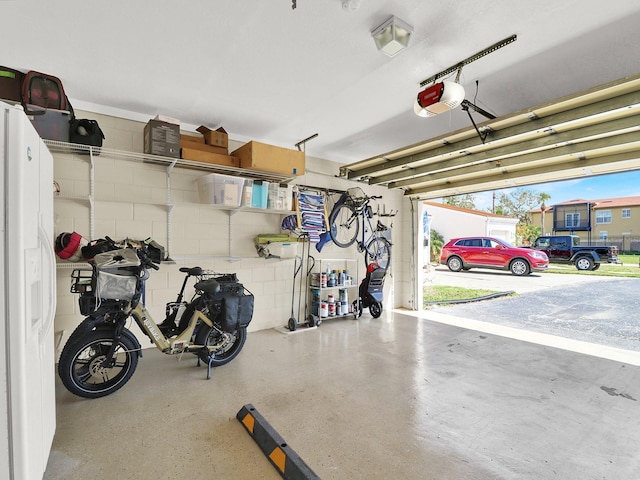 garage featuring a garage door opener and concrete block wall