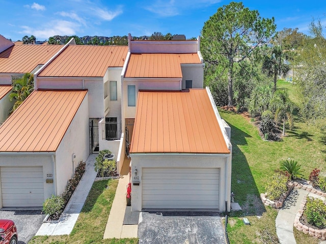 view of front facade featuring a standing seam roof, metal roof, and stucco siding