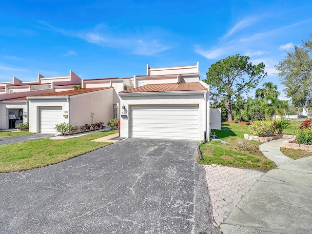 view of front of home featuring a garage, a standing seam roof, metal roof, and stucco siding