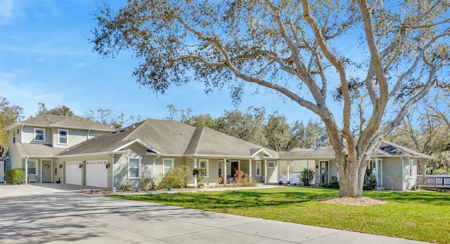 view of front of house with a garage, a front lawn, driveway, and stucco siding