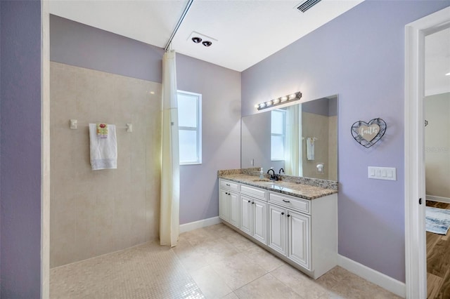 4411 Culbreath Rd, Valrico, FL 33596 - bathroom with vanity, visible vents, baseboards, tiled shower, and tile patterned flooring