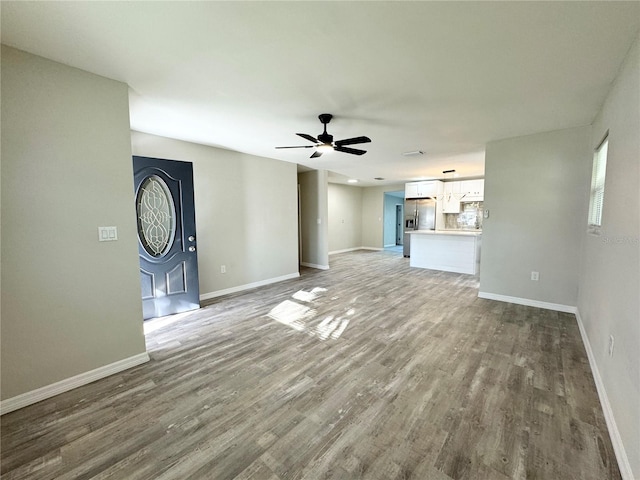 unfurnished living room featuring baseboards, ceiling fan, and wood finished floors