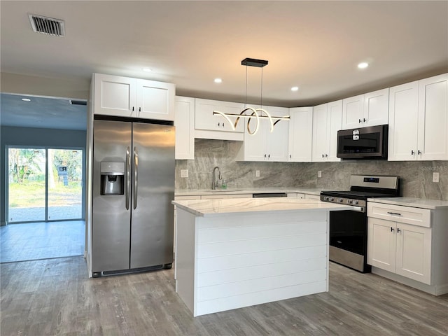 kitchen featuring a kitchen island, appliances with stainless steel finishes, wood finished floors, white cabinets, and a sink