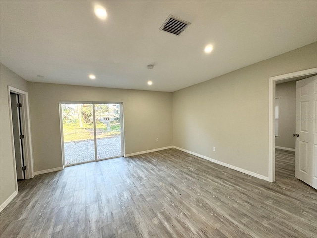 spare room with recessed lighting, visible vents, baseboards, and wood finished floors