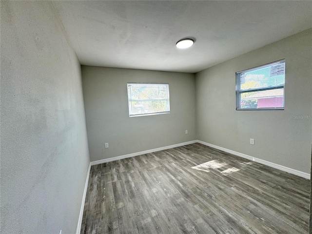 unfurnished room featuring baseboards and wood finished floors