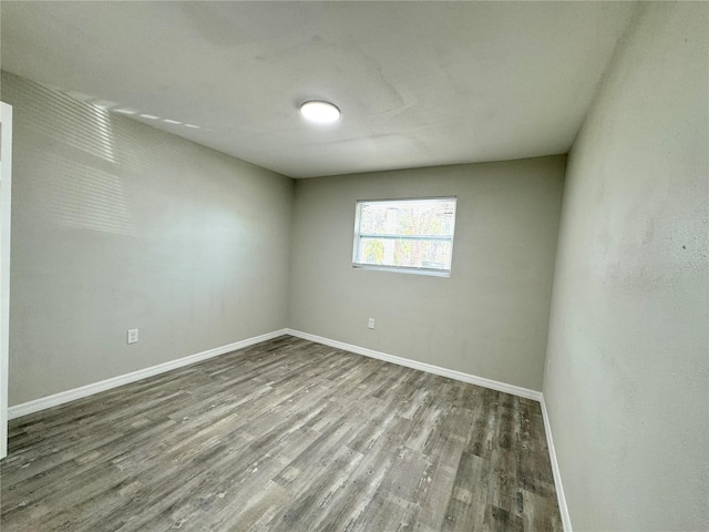 unfurnished room with baseboards and wood finished floors