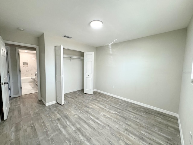 unfurnished bedroom with visible vents, baseboards, and wood finished floors