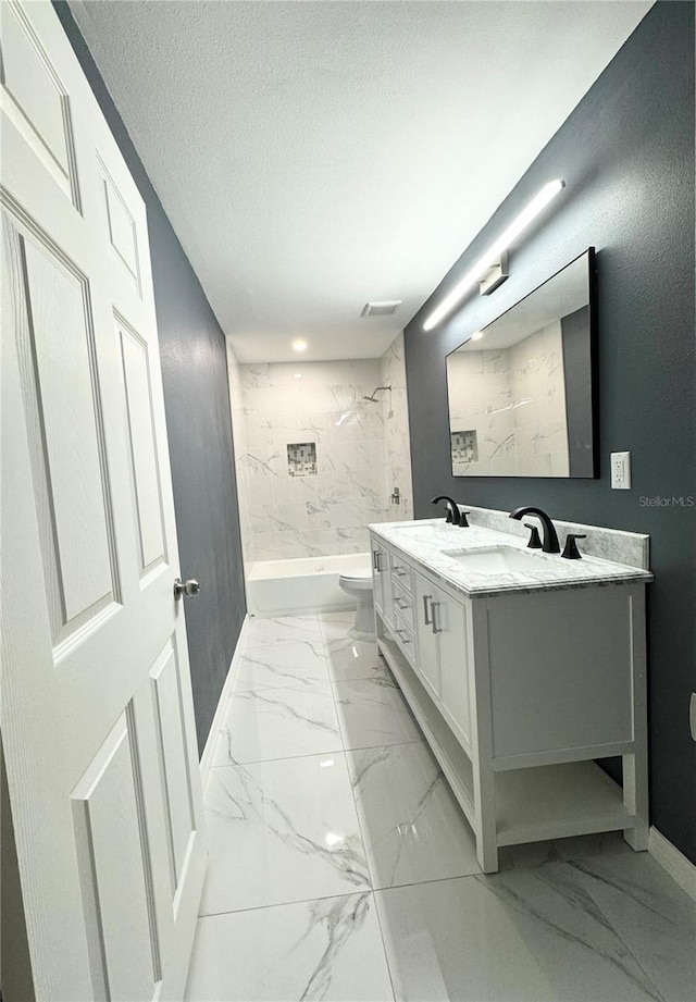 bathroom with vanity, a textured ceiling, bathing tub / shower combination, toilet, and marble finish floor