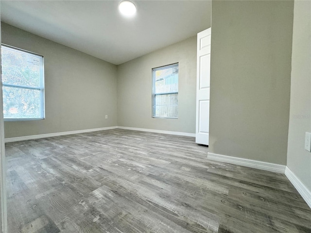 unfurnished room with baseboards and wood finished floors