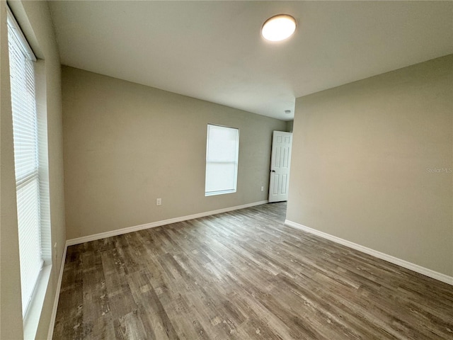 empty room with baseboards and wood finished floors