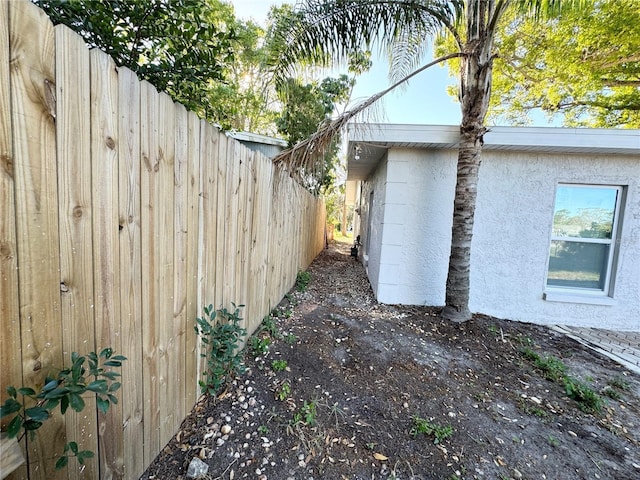 view of home's exterior featuring stucco siding and fence