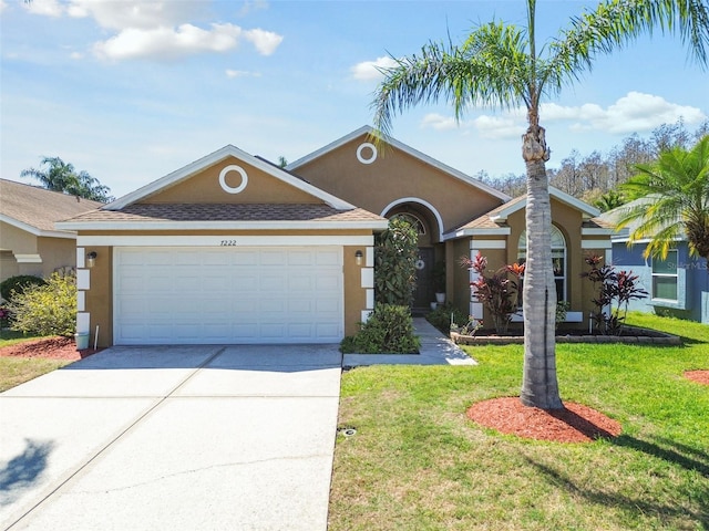 single story home with a garage, driveway, a front yard, and stucco siding