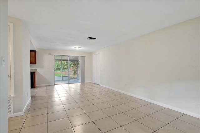 empty room featuring visible vents, baseboards, and light tile patterned flooring