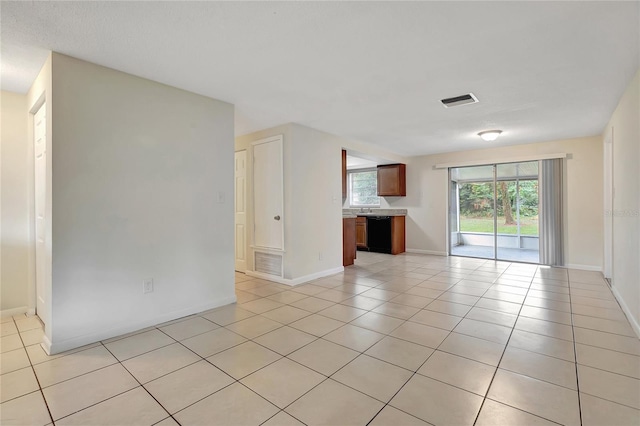 empty room featuring light tile patterned floors, baseboards, and visible vents