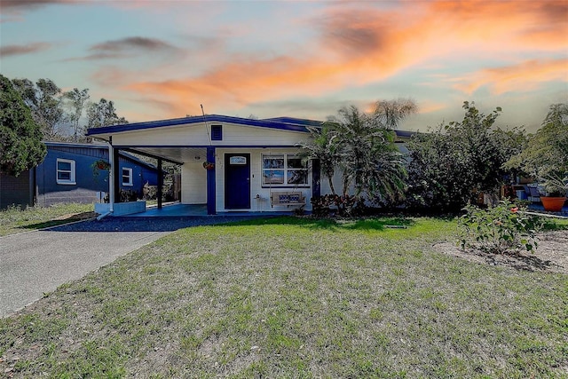 view of front of home featuring covered porch, aphalt driveway, an attached carport, and a front yard