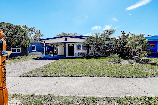 view of front facade with driveway, a front lawn, and a carport