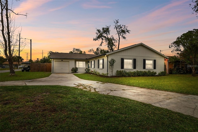 ranch-style home with driveway, an attached garage, fence, a front lawn, and brick siding