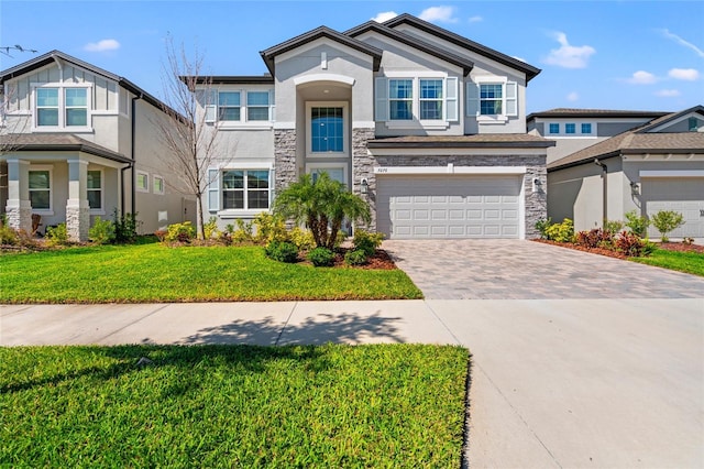 view of front of home featuring stone siding, decorative driveway, an attached garage, and stucco siding