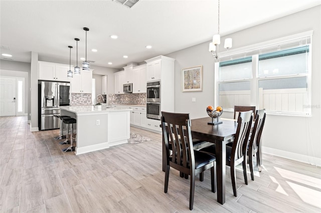 dining area featuring baseboards, recessed lighting, and light wood-style floors