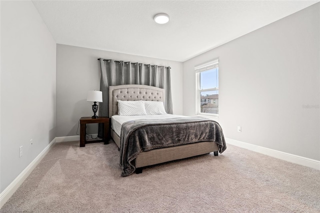 bedroom featuring baseboards and light colored carpet